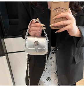 Detail view of silver mini crossbody bag with metal C logo and delicate chain strap