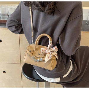 Detailansicht einer hellbraunen Mini-Handtasche mit Seidenschal-Griff und Umhängeriemen