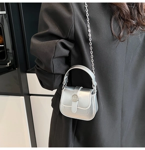 Macro detail of silver mini crossbody bag showing metallic finish and C-buckle