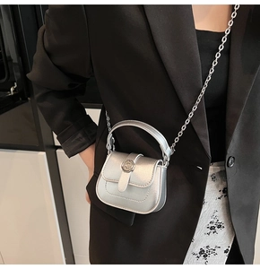 Silver mini crossbody bag with a flower-shaped metal buckle and a chain shoulder strap