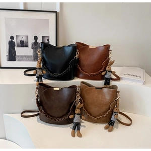 Detail of vintage bucket bags with metal bars and cute bunny charms in four colors
