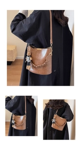 Detail view of a vintage brown bucket bag with woven chain and cute rabbit plush charm