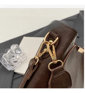 Macro shot of polished gold metal hooks and hardware on a vintage brown leather bag