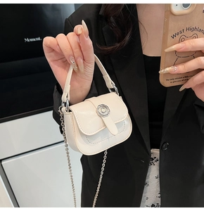 Close-up of cream mini square bag with silver C-lock buckle and metallic chain strap
