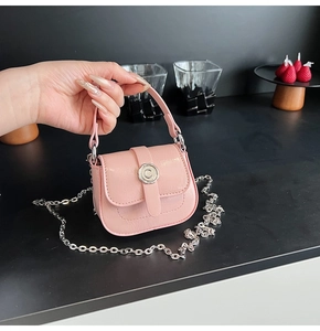 Close-up of a pink mini crossbody bag with a silver C-logo and chain strap detail