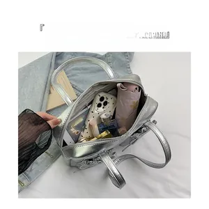 Spacious interior of silver metallic shoulder bag showing large capacity for essentials