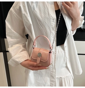 Pink mini crossbody bag with silver C-logo buckle and chain strap on white shirt outfit