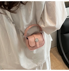 Back view of a pink mini crossbody bag with metal chain strap on a white shirt