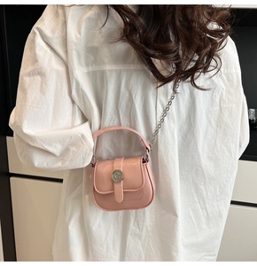 Detail of pink mini crossbody bag with glossy finish and C logo on white shirt