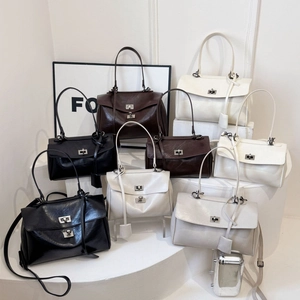 Minimalist oil-wax leather handbag for women in black brown and cream on pedestals