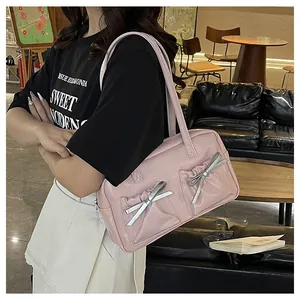 Pink shoulder tote bag with silver bow details and pleated pockets shown on model