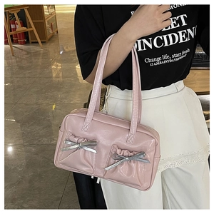 Detail of pink leather tote bag with silver bow accents and ruched pockets