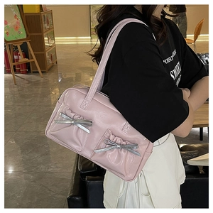 Detail of pink PU leather shoulder bag with pleated pockets and silver bow decorations
