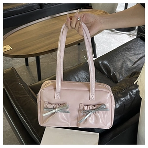 Close-up of pink tote bag showing pleated pockets and silver metallic bow detail