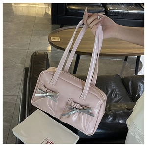 Detail of pink patent leather tote bag with stylish pleated bow pockets and top zipper