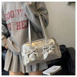 Detail of silver metallic Boston bag with bow accents and wrinkled PU leather texture
