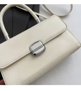 Détail du sac en similicuir crème montrant la boucle en métal argenté et la texture douce