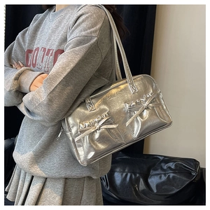Detail view of silver metallic shoulder bag with bow accents and crinkled PU leather texture