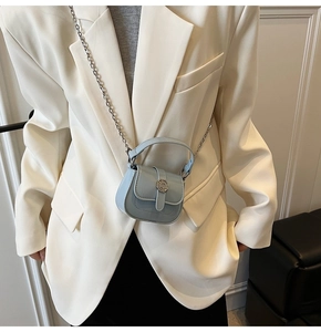 Close-up of mini light blue patent leather crossbody bag with silver chain and metal buckle