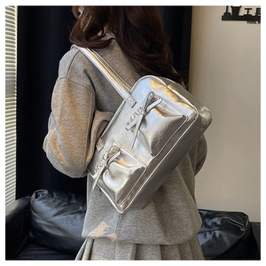 Detail view of silver Y2K shoulder bag featuring metallic finish and bow ornaments