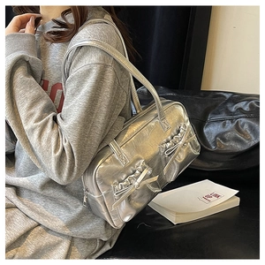 Close-up of silver bow tote bag showing metallic cracked leather texture and chic design