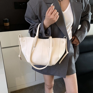 Schicke beige Achseltasche aus Leder mit Lychee-Muster, kombiniert mit grauem Blazer