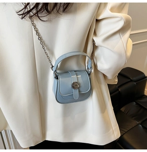 Detail of light blue mini square bag with metal chain strap and ring buckle closure