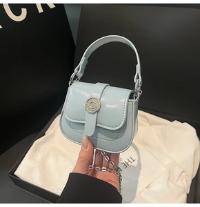 Close-up of light blue mini square bag with silver C-buckle and elegant chain strap