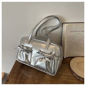 Detailed close-up of silver bow pockets on the metallic褶皱 textured handbag texture