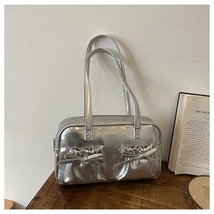 Detail of silver metallic tote bag with decorative bows and wrinkled texture pockets