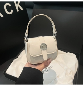 Detail of cream mini square bag featuring a round metal C logo buckle and chain strap
