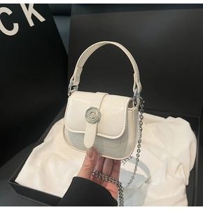 Detail view of mini cream crossbody bag with silver C-logo clasp in premium gift box