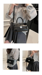 Détail du sac bandoulière en cuir noir avec boucle argentée et bandoulière amovible