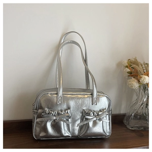 Close-up of metallic silver tote bag with bow detail and wrinkled leather texture