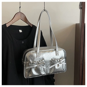 Detail of silver metallic tote bag showing bow pockets and distressed texture