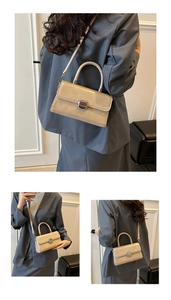 Vue détaillée d'un sac bandoulière beige avec finition lisse et fermoir en métal argenté