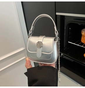 Detailed view of silver metallic mini bag featuring a circular C logo and chain strap