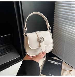Close-up of a white mini handbag with lychee texture and silver chain strap