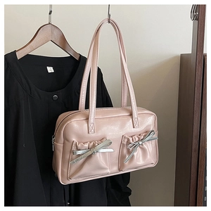 Detail of pink faux leather tote bag with silver metallic bows and gathered front pockets