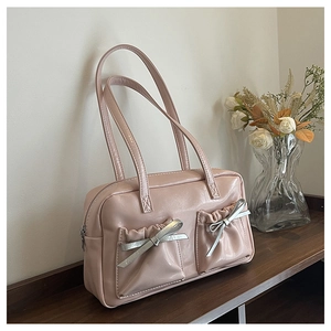 Detail of pink glossy PU tote bag featuring silver bow accents and metallic zipper closure