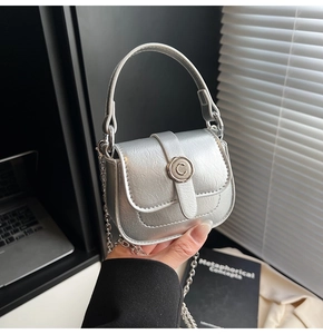 Detail of silver mini bag with metallic pebble leather and round C buckle in hand