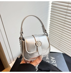 Detail of silver mini square bag with metallic texture, C-letter buckle and chain strap
