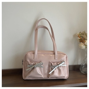 Detail of pink bow tote bag showing glossy finish and decorative wrinkled pockets