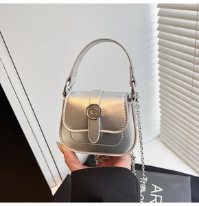 Detail of silver metallic mini bag featuring a textured finish and vintage letter C buckle