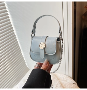 Detail of glacier blue mini saddle bag with vintage textured leather and silver C buckle
