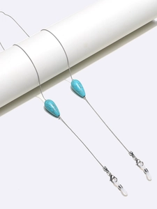 Detailed shot of silver eyewear chain with turquoise teardrop beads and rubber grips