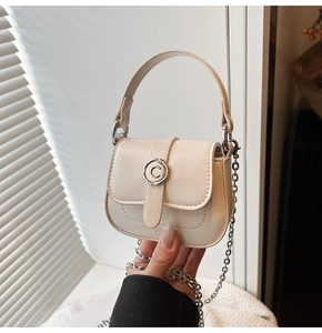 Close-up of cream leather mini bag featuring round C-letter buckle and silver chain strap
