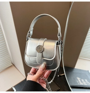 Detailed close-up of a silver mini bag featuring a sleek C-shaped metal clasp and chain strap