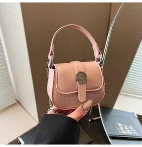 Detail of pink lychee grain mini bag with silver C-buckle and metal chain strap