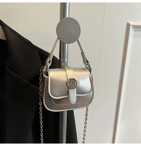Detail of silver chain bag with crinkled texture leather and round metal buckle